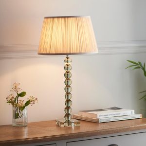 Adelie green crystal table lamp with oyster silk shade on sitting room sideboard