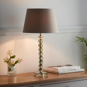 Adelie stacked green crystal table lamp with grey linen mix shade on lounge sideboard