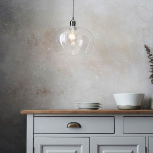 Medium clear glass kitchen pendant in polished nickel, shown over kitchen unlit.