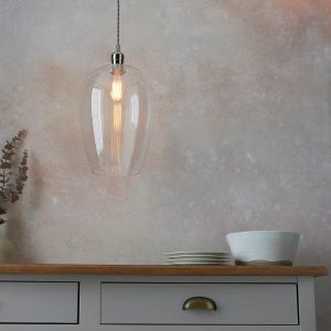 Large clear glass kitchen pendant in polished nickel, shown over kitchen side table.