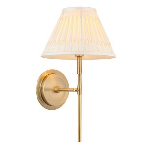 Rennes antique brass wall light with ivory silk shade on white background lit