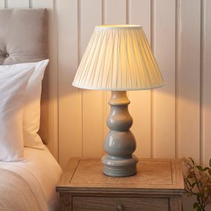 Provence grey ceramic table lamp with ivory silk shade on bedside table lit