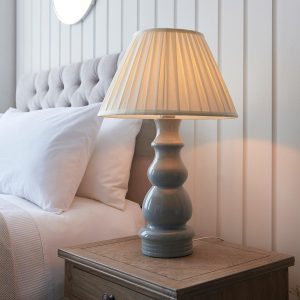 Provence grey ceramic table lamp with box pleat cream shade on bedside table