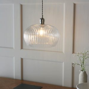 Timeless medium ribbed glass kitchen pendant in polished nickel, angled view above dining room sideboard.