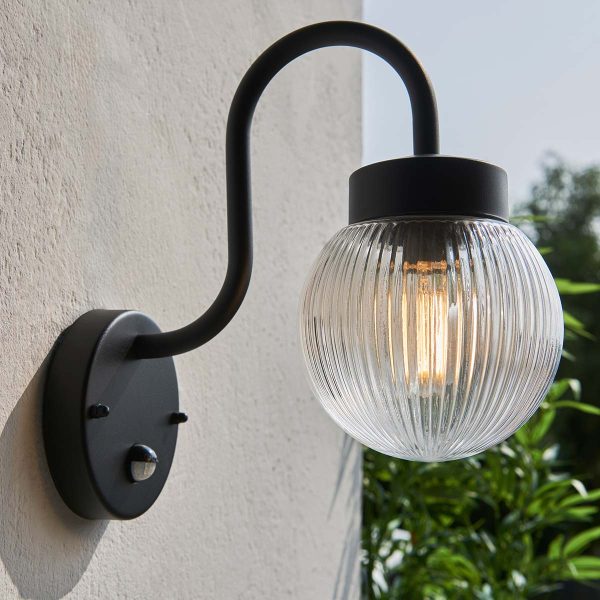 Eldon traditional outdoor PIR wall light in textured black, shown on garden wall