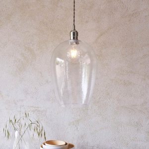 Timeless large hammered glass kitchen pendant in polished nickel, shown over a sideboard.