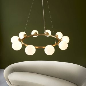 Large modern round 10 light pendant in satin brass with opal glass shades, shown over a sofa.