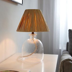 Lyra textured glass table lamp with raffia shade, main image on sideboard