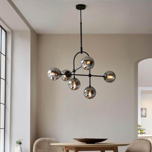 Telescopic matt black 6 light pendant with mirrored smoked glass globe shades, shown above a dining room table.