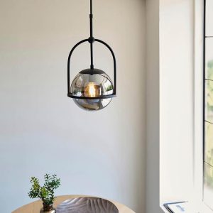 Telescopic matt black single light pendant with mirrored smoked glass globe shades, shown over a small dining table.