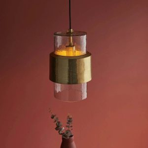 Small textured glass kitchen pendant in hammered brass, shown in a burgundy room.