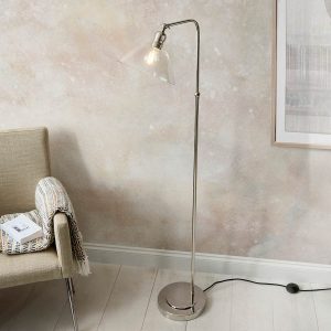 Classic polished nickel floor lamp with clear glass shade, shown in a sitting area.