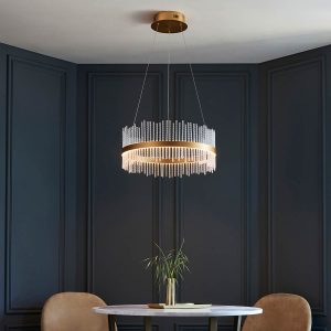 Small matt gold LED hoop pendant with twisted glass rods, shown over a dining room table.