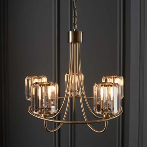 Berenice 5 light antique brass chandelier hanging in grey panelled room