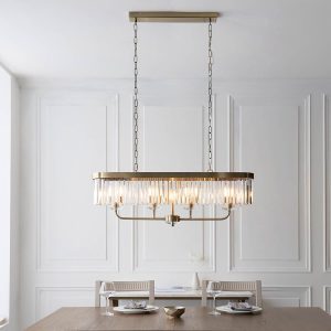 Linear 4 light pendant in antique brass with cut glass drops, shown over a rectangular dining room table.