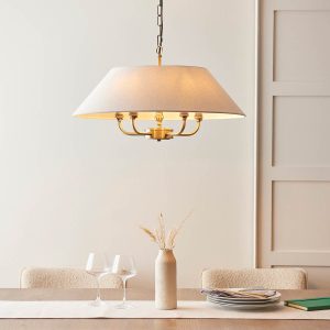 Lille antique brass 5 light pendant with natural faux linen shade, shown over dining room table.