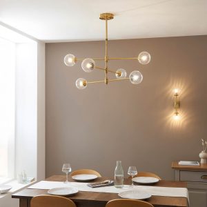 Telescopic aged brass 6 light pendant with twisted clear glass shades, shown over a dining room table.