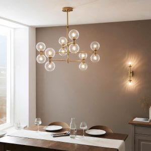 Telescopic aged brass 12 light pendant with twisted clear glass shades, shown over a dining room table.