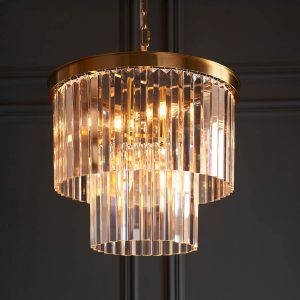 Conaston 4 light pendant in brushed aged brass with glass prisms, shown in panelled room.