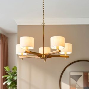 Heathcliff 5 light chandelier in brushed aged brass and wood with natural faux linen shades, on dining room ceiling.