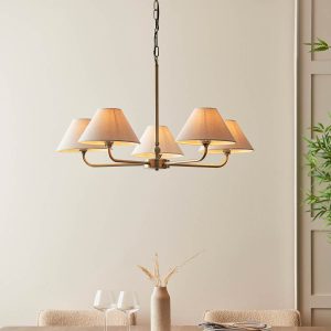 Lille 5 light antique brass chandelier with natural faux linen shades, shown over dining room table.