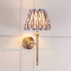 Lille single antique brass wall light with grey Ikat shade, shown on panelled wall.