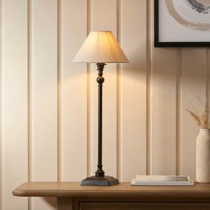 Lille small candlestick table lamp in matt black with natural faux linen shade, on lounge side table.