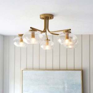 Jacob 5 light semi flush in aged brass with bubble glass shades, shown in room setting.