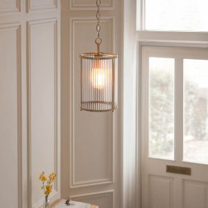 Ridgeton 1 light pendant in antique brass with clear ribbed glass shade, shown in entrance hall.