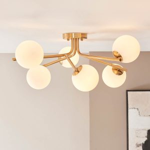 Aaron 6 light semi flush ceiling light in brushed aged brass, shown on room ceiling.