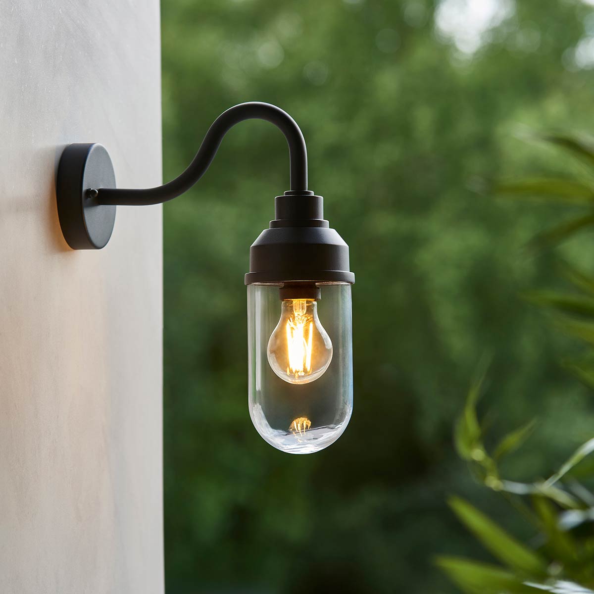 Truro swan neck outdoor wall light in matt black and rated IP44, shown on an exterior wall corner.