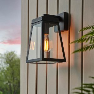 Lymington outdoor wall lantern in matt black with clear glass panels, shown on exterior panelled wall.