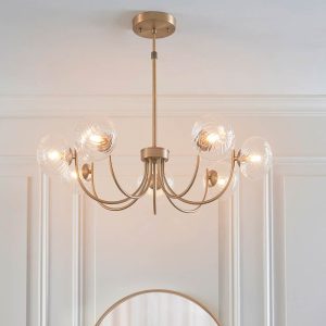 Hague 7 light chandelier in antique brass with twisted clear glass shades, on room ceiling.