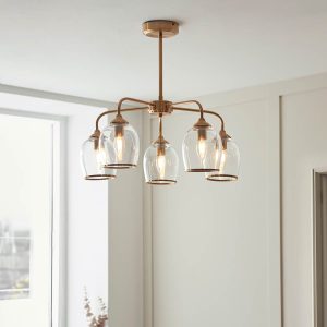 Ashcroft 5 light pendant in brushed aged brass with clear glass goblet shades, shown on dining room ceiling.