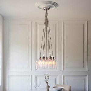 7 light cluster pendant in polished nickel with clear glass goblet shades, shown full height over dining room table.