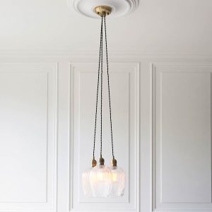 3 light cluster pendant in antique brass with ribbed glass goblet shades, shown in panelled room.