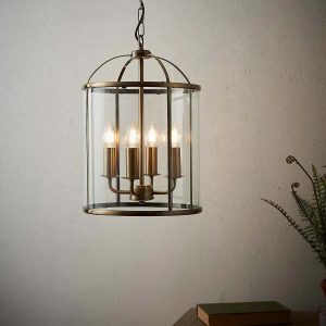 Lambeth 4 light pendant lantern in antique brass hanging in room lit