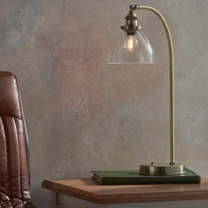 Hansen industrial table lamp in antique brass, next to chair on sitting room table