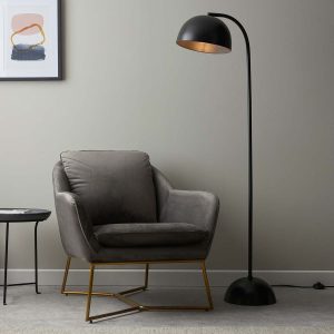 Brodey industrial style floor lamp in matt black, next to chair in sitting room