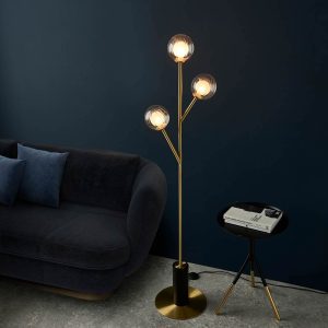 3 light floor lamp in satin brass with ribbed and frosted glass shades, shown in a lounge.