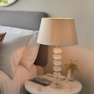 Annabelle frosted crystal table lamp in brushed gold with ivory shade on bedside table