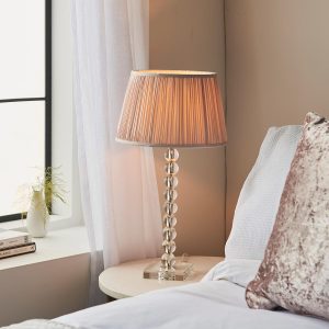 Adelie stacked clear crystal table lamp with dusky pink silk shade on bedside table