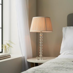 Adelie stacked clear crystal table lamp with oyster silk shade on bedside table