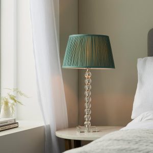 Adelie stacked clear crystal table lamp with fir green silk shade on bedside table