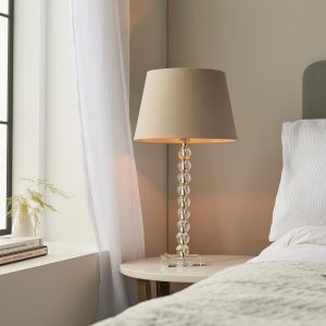 Adelie stacked clear crystal table lamp with grey linen mix shade on bedside table