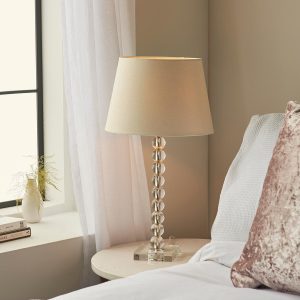 Adelie stacked clear crystal table lamp with ivory linen mix shade on bedside table