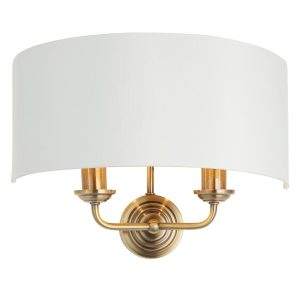 Highclere twin wall light in antique brass on white background