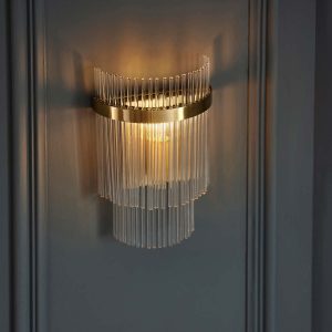Marietta antique brass wall light with clear glass rods on panelled wall