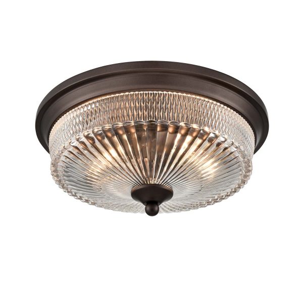 Emerson 2 light flush ceiling light in dark brown with clear ribbed glass shade, on white background, lit.