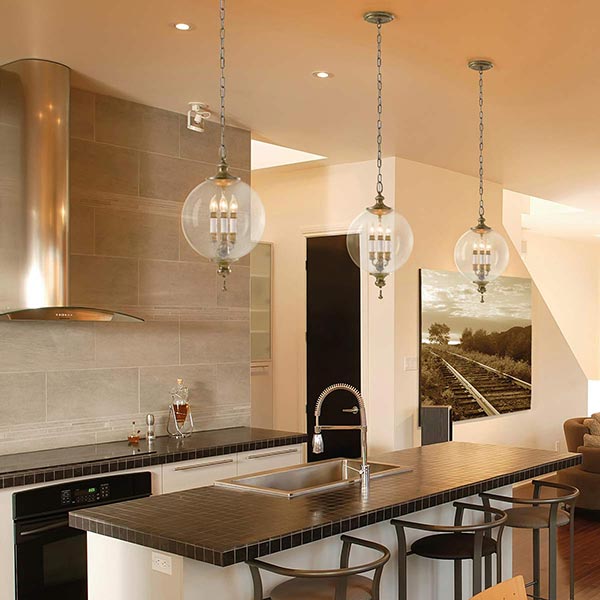 Modern kitchen showing three globes hanging over breakfast bar.